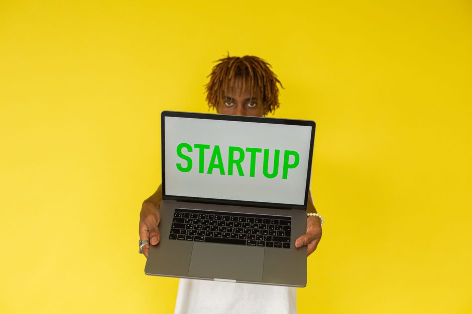 Mladić s laptopom prikazuje startup projekt